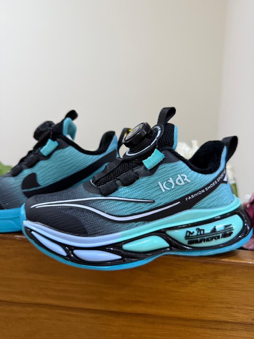 Bold turquoise-black sneakers with futuristic soles, perfect for your little explorer.