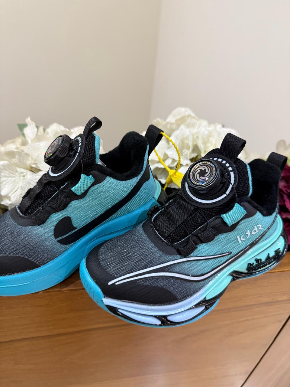 Bold turquoise-black sneakers with futuristic soles, perfect for your little explorer.